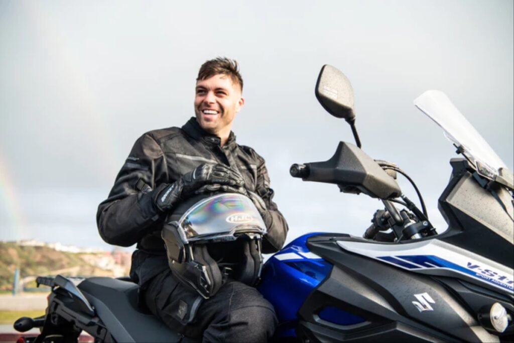 un casque de moto hjc i100 avec un motard souriant sur une vstrom